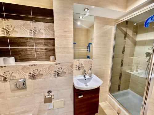 a bathroom with a sink and a shower at SAWA 6 metro fast WiFi 70'TV panorama HBO, Netflix, Dsiney+ in Warsaw