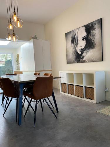 een eetkamer met een tafel en stoelen bij Ruime woning met 4 slaapkamers nabij Antwerpen en haven in Brasschaat