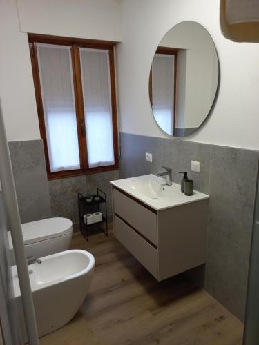 a bathroom with a sink and a toilet and a mirror at Monolocale Il Piccolo Rusca in Santa Maria Maggiore