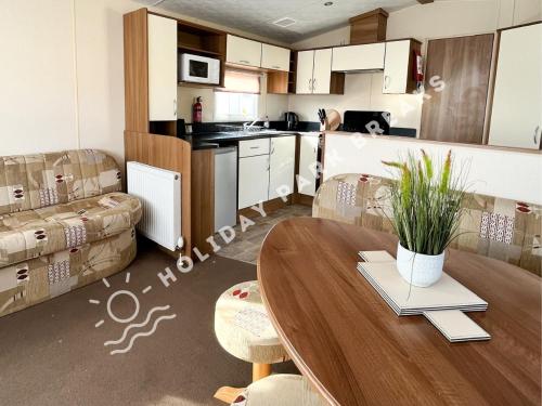 cocina y sala de estar con mesa y sofá en Homely 3 bed - Sleeps 8 @ Seal Bay, Selsey en Chichester