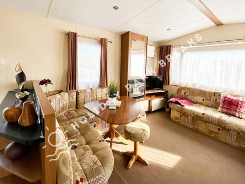 a living room with a couch and a table at Homely 3 bed - Sleeps 8 @ Seal Bay, Selsey in Chichester