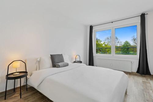 ein weißes Schlafzimmer mit einem großen Bett und einem Fenster in der Unterkunft Tranquil Haven - Relax and Unwind in Hamm ID23 in Luxemburg (Stadt)