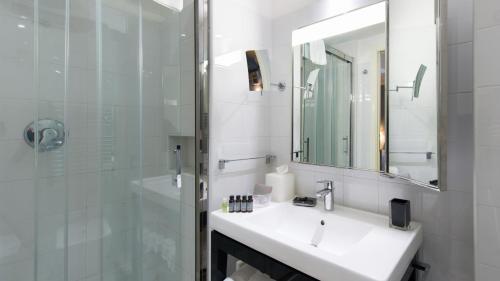 a white bathroom with a sink and a shower at Santa Chiara Boutique Hotel in Naples