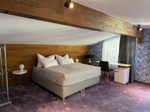 1 dormitorio con 1 cama grande y escritorio en Two Brothers Inn en Pertisau