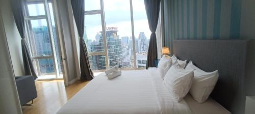 a bedroom with a large bed with a large window at SKYWARD SUITE KLCC in Kuala Lumpur