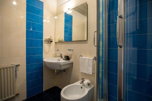 a bathroom with a sink and a toilet and a mirror at Hotel Palace del Conero in Osimo