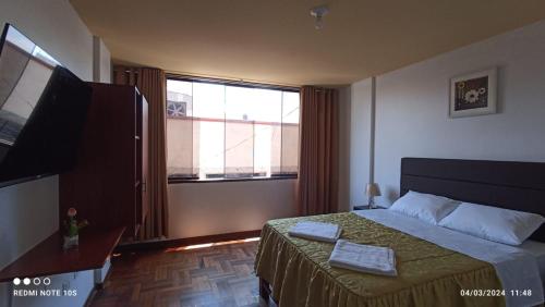 a bedroom with a bed and a large window at Montecristo Hotel in Tacna