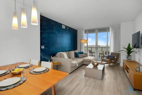 a living room with a couch and a dining room at Infinite View and Balcony with Pool, Gym, Near Beach in Hallandale Beach