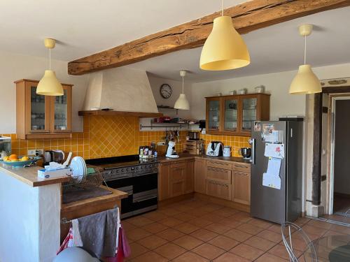 een keuken met houten kasten en een roestvrijstalen koelkast bij Du coté de chez Flo in Bazas