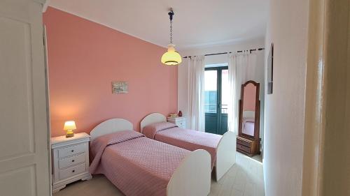 2 bedden in een slaapkamer met roze muren bij Sky Apartment by Casa in mente in Cefalù