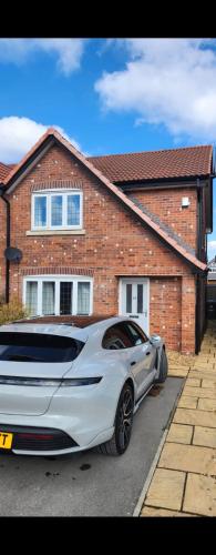 a white car parked in front of a house at Moorgreen in Bircotes