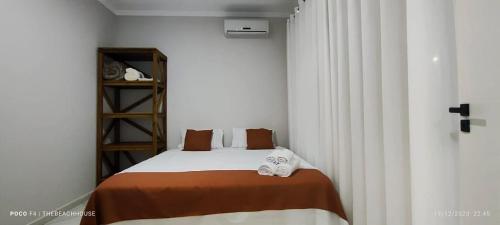 Un pequeño dormitorio con una cama con toallas. en The Beach House Estadias, en Boa Vista