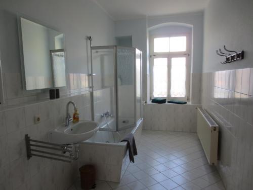 La salle de bains est pourvue d'un lavabo, d'une douche et d'une baignoire. dans l'établissement Haus Gründerzeit, à Görlitz