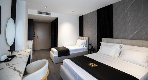 a hotel room with two beds and a chair at Destiny Hotel & SPA in Tirana