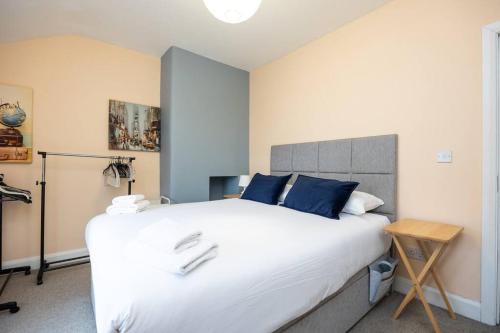 una camera da letto con un grande letto bianco con cuscini blu di Super 2-Bed House 5 min to Harcourt Tram Stop a Dublino
