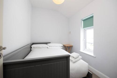 a bed in a room with a window at Super 2-Bed House 5 min to Harcourt Tram Stop in Dublin