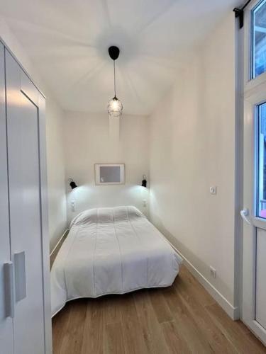 une chambre blanche avec un lit et une fenêtre dans l'établissement Le Printemps * Bel appartement climatisé * Hypercentre, à Toulouse