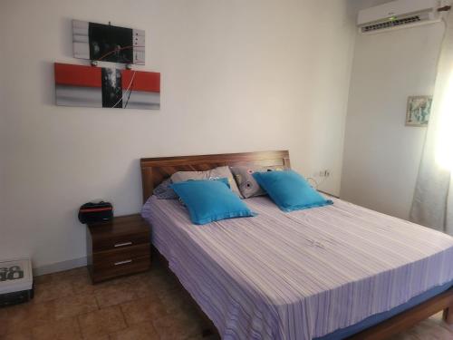 een slaapkamer met een bed met twee blauwe kussens bij Elyas-House in Djibouti