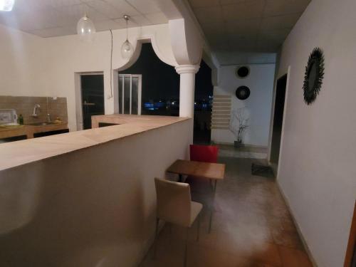 a kitchen with a counter and a table and a chair at Elyas-House in Djibouti