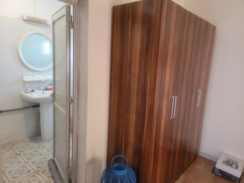 un armario de madera en el baño con lavabo en Elyas-House en Yibuti