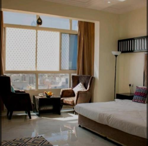 een slaapkamer met een bed en een woonkamer bij قصائد in Salalah