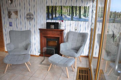 a living room with two chairs and a fireplace at Leuchttürmchen in Marienleuchte