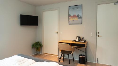 a bedroom with a desk and a bed and a room at Hotel Smedegaarden in Lem
