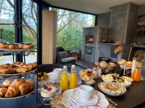 a table with a bunch of bread and pastries on it at B&B Miranoza in Oud-Heverlee