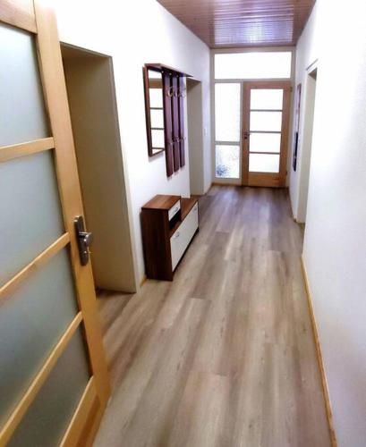 an empty room with a hallway with a door and wooden floors at Moderne Wohnung für bis zu 4 Personen in Eschenbach in der Oberpfalz