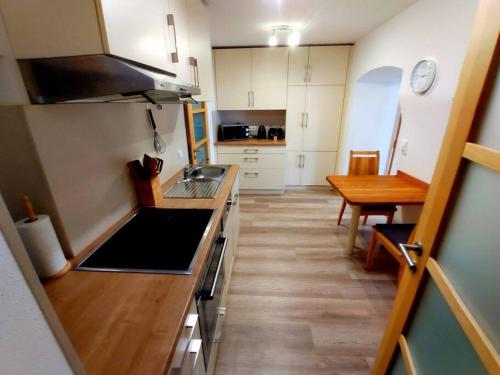 Moderne Wohnung für bis zu 4 Personen في Eschenbach in der Oberpfalz: مطبخ صغير مع حوض وطاولة