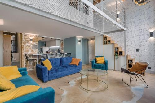 un salon avec des canapés bleus et une table en verre dans l'établissement Le Bourgelat / 3 ch / 6 pers / 2 sdb, à Lyon