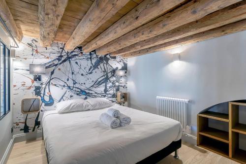 une chambre avec un grand lit avec des serviettes dessus dans l'établissement Le Bourgelat / 3 ch / 6 pers / 2 sdb, à Lyon