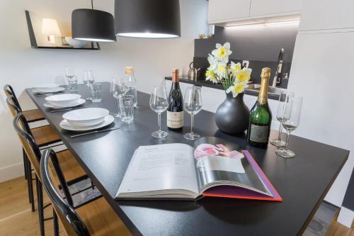 a table with a book and wine bottles and glasses at La Suite Boissac - Cœur de Lyon - Bellecour in Lyon