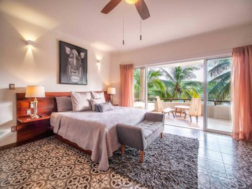 une chambre avec un lit et une grande fenêtre dans l'établissement Casa Maka - Stunning Oceanfront Villa, à Santa Cruz Huatulco