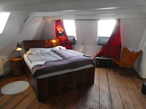 a bedroom with a bed and red curtains at Zimmer Und Aussicht in Friedrichstadt