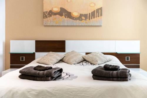 a large white bed with two pillows on it at Cozy 3BD Seaside Apartment! WiFi and Great Location! in Tal-Għoqod
