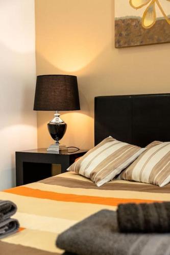 a bedroom with a bed with a lamp on a table at Cozy 3BD Seaside Apartment! WiFi and Great Location! in Tal-Għoqod