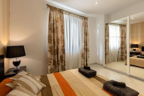 a bedroom with a bed and a large mirror at Cozy 3BD Seaside Apartment! WiFi and Great Location! in Tal-Għoqod