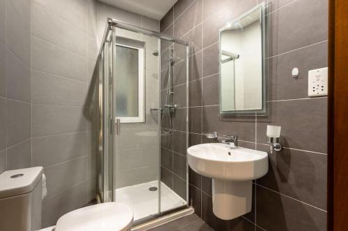 a bathroom with a sink and a toilet and a shower at Cozy 3BD Seaside Apartment! WiFi and Great Location! in Tal-Għoqod