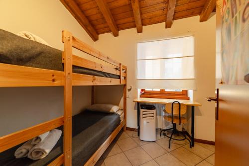 a bedroom with two bunk beds and a desk at Villa Valya by GardaDoma in Brenzone sul Garda