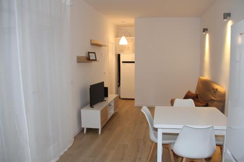 een woonkamer met een witte tafel en een tv bij Los palomares in El Casar de Talamanca