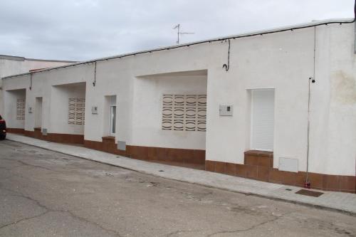 een rij witte gebouwen op een straat bij Los palomares in El Casar de Talamanca