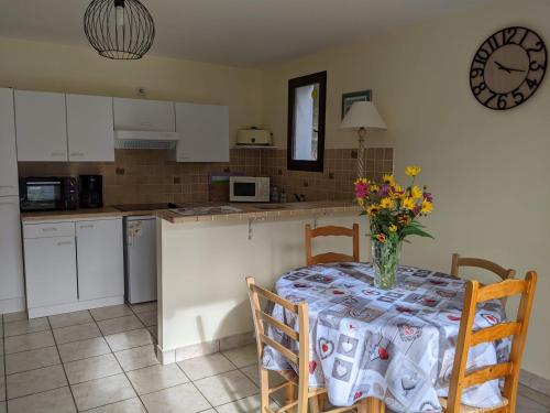 une cuisine avec une table avec un vase de fleurs dessus dans l'établissement Gîte en montagne : La Terrasse du Rabioux, à Châteauroux-les-Alpes