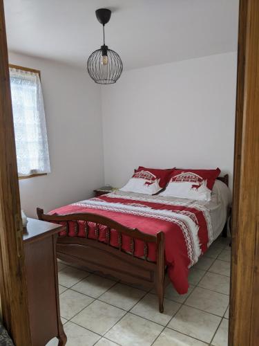 - une chambre avec un lit et une couette rouge et blanche dans l'établissement Gîte en montagne : La Terrasse du Rabioux, à Châteauroux-les-Alpes