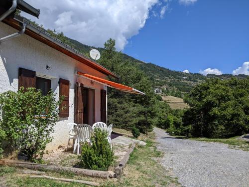 una casa con due sedie bianche sedute fuori di Gîte en montagne : La Terrasse du Rabioux a Chateauroux-les-Alpes