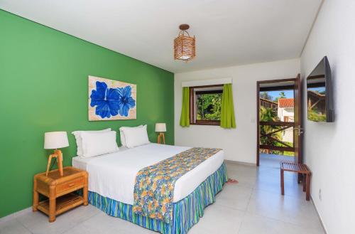 1 dormitorio con cama y pared verde en Armação Resort Porto de Galinhas, en Porto de Galinhas