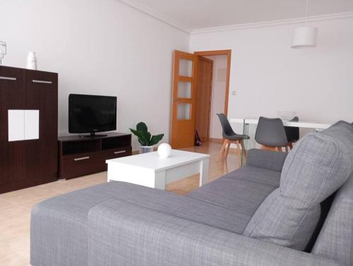 ein Wohnzimmer mit einem Sofa und einem TV in der Unterkunft Confortable y nuevo cerca del Casco antiguo in Caravaca de la Cruz