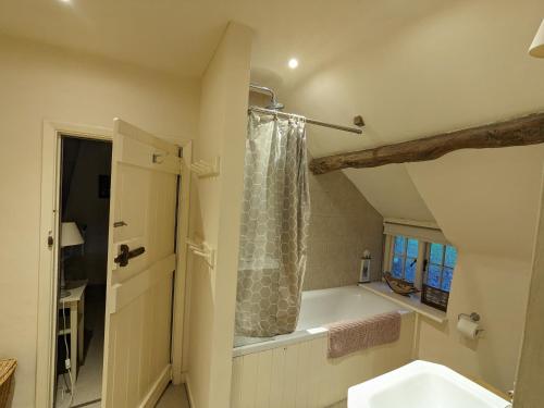 uma casa de banho com um lavatório e um chuveiro em Afton Thatch: Beautiful Thatched Family Cottage em Freshwater