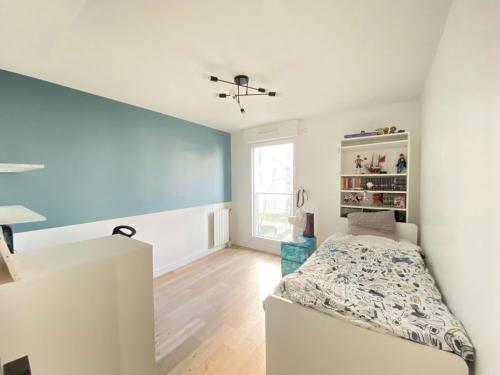 une chambre avec un lit et une fenêtre dans l'établissement Appartement familial de standing, à Boulogne-Billancourt