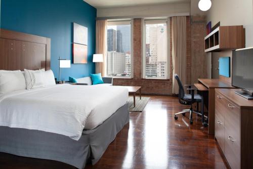 TownePlace Suites by Marriott Dallas Downtown في دالاس: غرفة في الفندق بها سرير ومكتب وبه جهاز كمبيوتر
